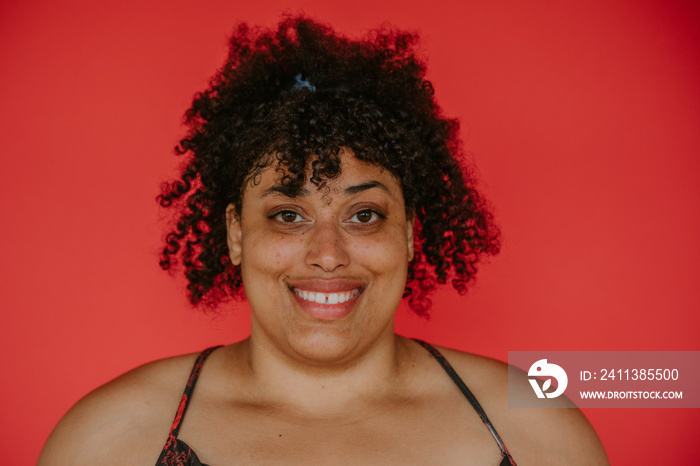 centered portrait of a plus size afro indigenous person on red backdrop