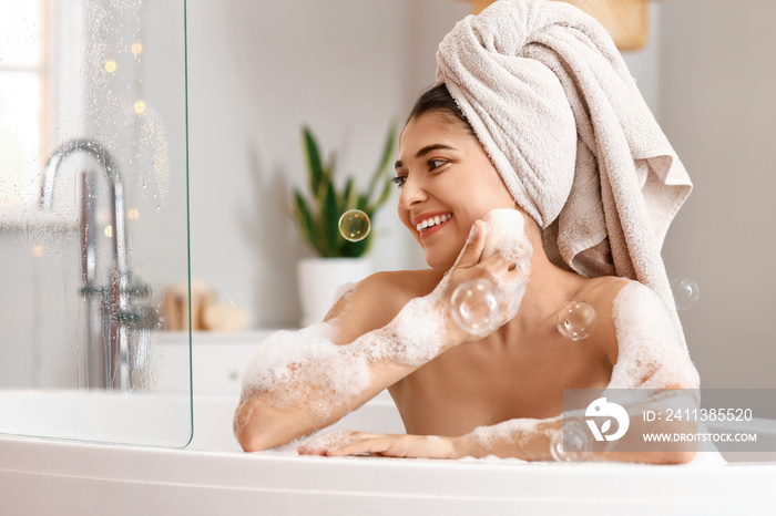 Pretty young woman taking bath at home