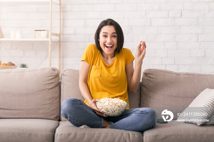 Lockdown leisure activities. Young girl laughing while watching funny movie at home