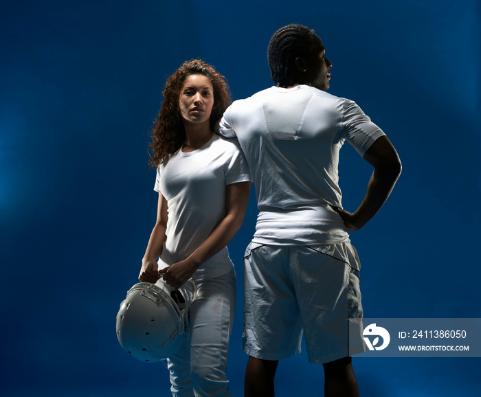 Studio portrait of male and female with football helmet