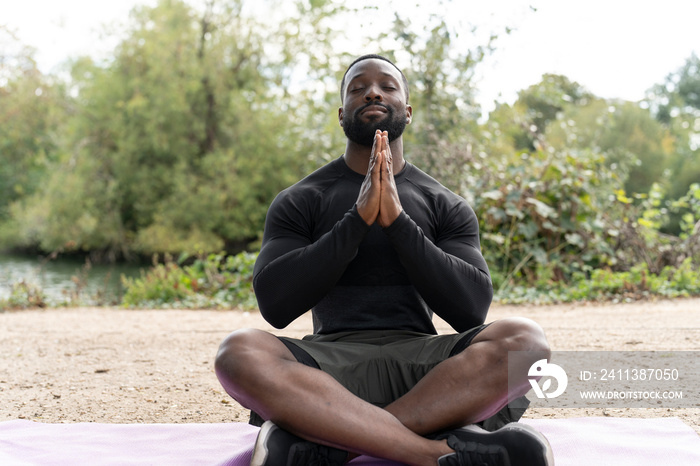 Athletic man meditating in park