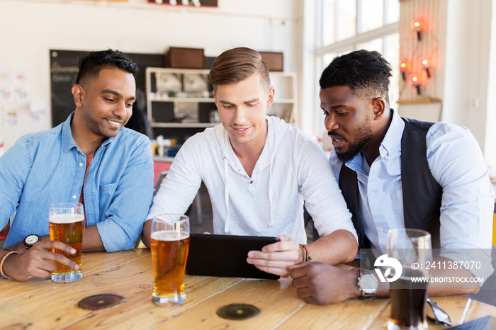 male friends with tablet pc drinking beer at bar