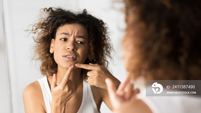 Afro Girl Squeezing Pimple Looking In Mirror In Bathroom, Panorama