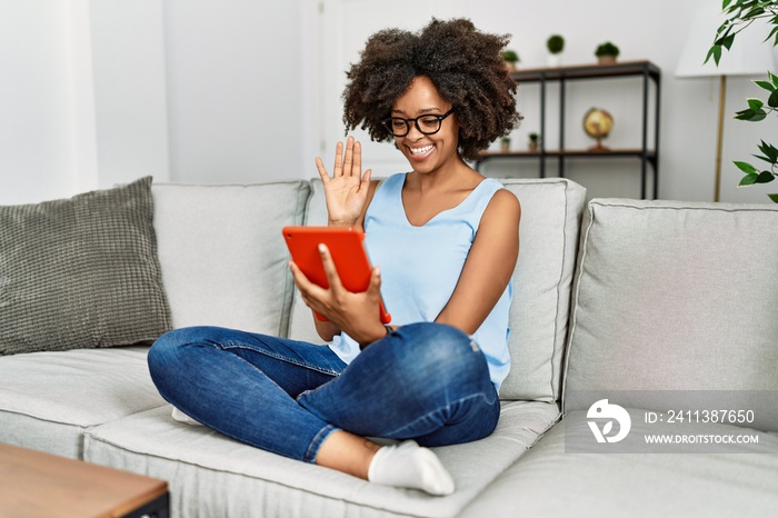 Young african american woman smiling confident using touchpad at home