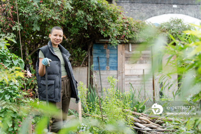 Portrait of woman standing in urban vegetable garden