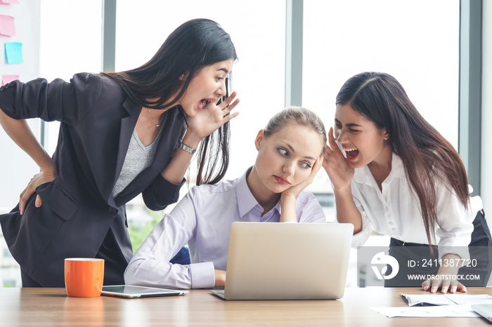 Two Asian businesswomen yelling at female Caucasian coworker. Working environment and abuse concept.