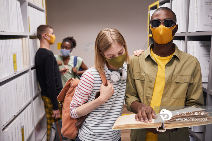 Waist up portrait of diverse group of students in library with blind man in foreground