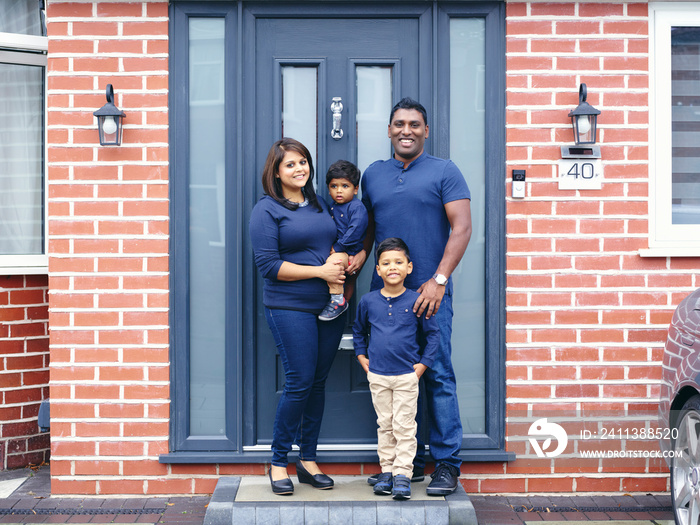 Portrait of family with sons standing on doorstep