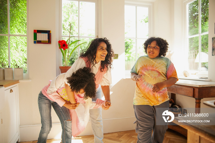 Curvy mother having fun with her children in the kitchen