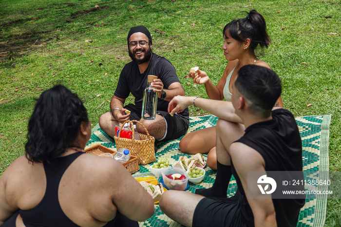 Group of friends enjoying a picnic together in the park