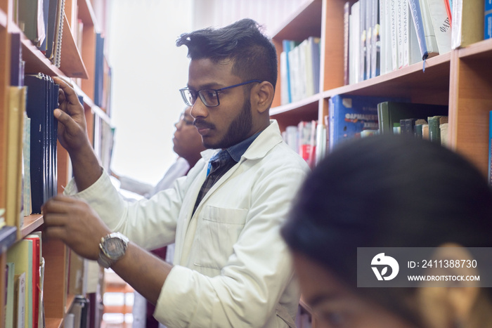 group of students of medical university, college, mixed race, while in the library, reads medical literature