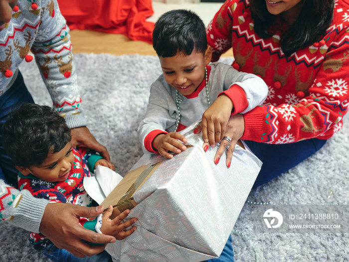 Family with sons opening Christmas presents