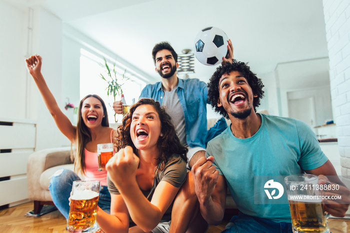 Happy friends or football fans watching soccer on tv and celebrating victory at home.Friendship, sports and entertainment concept.