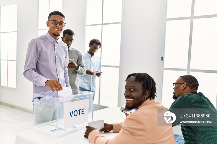 Group of young african american voter people putting vote in ballot standing at electoral center.