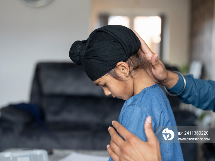 Father wrapping turban around son’s head (6-7)