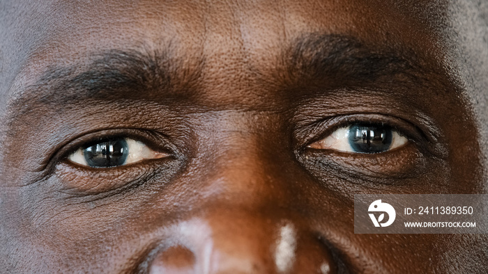 Extreme close up body part human male wrinkled face african american senior elderly adult man with dark iris eyesight masculine person looking at camera with healthy expression ophthalmology service