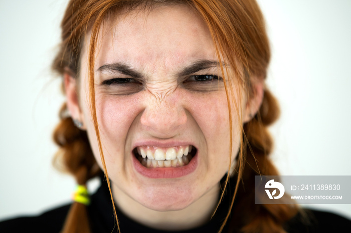 Close up portrait of angry redhead teenage girl.