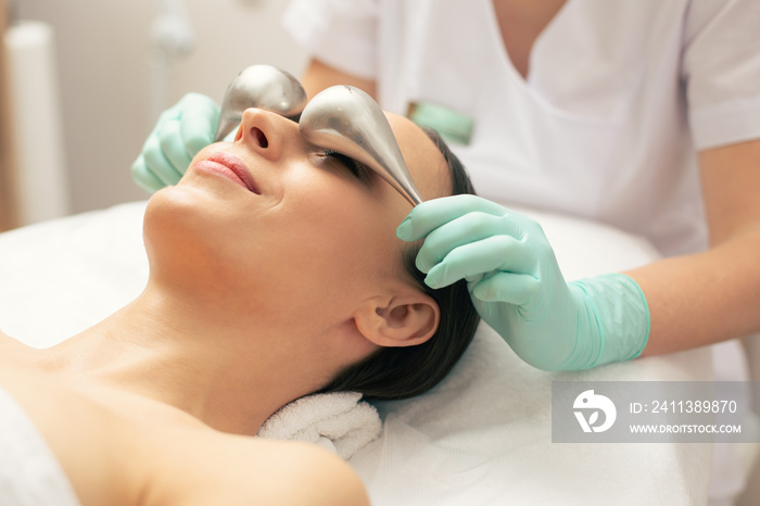 Modern cryo-sticks above the eyes of smiling woman