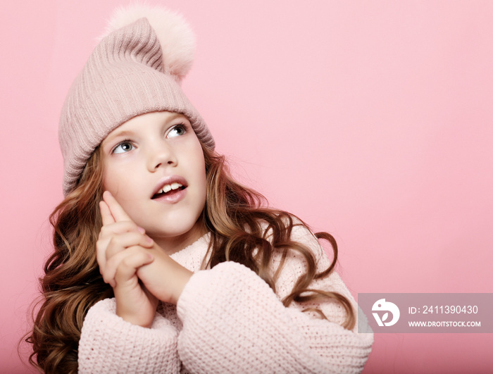 little girl child wearing pink winter hat and sweater over pink background, close up