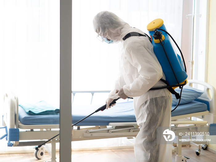 Man in Hazmat protective suits disinfecting in hospital room during outbreak of Coronavirus, Covid-19.