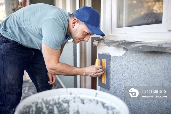 Man working on a house facade.