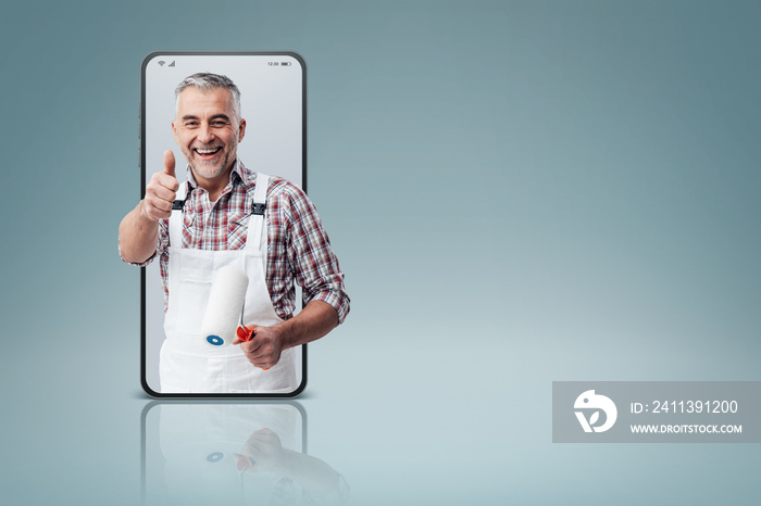 Confident painter and decorator  in a smartphone videocall and smiling, online  service concept