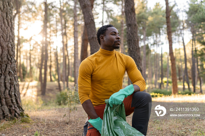 african american man, volunteer collect garbage in the forest, concept of environmentalism care for the environment.