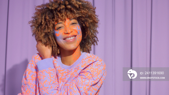 Closeup portrait of mixed race woman with neon makeup . new beauty concept, authentic identity Happy smiling black woman with creative face bodypaint