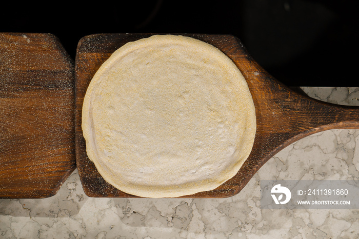 Professional restaurant kitchen - prepared pizza dough to create pizza