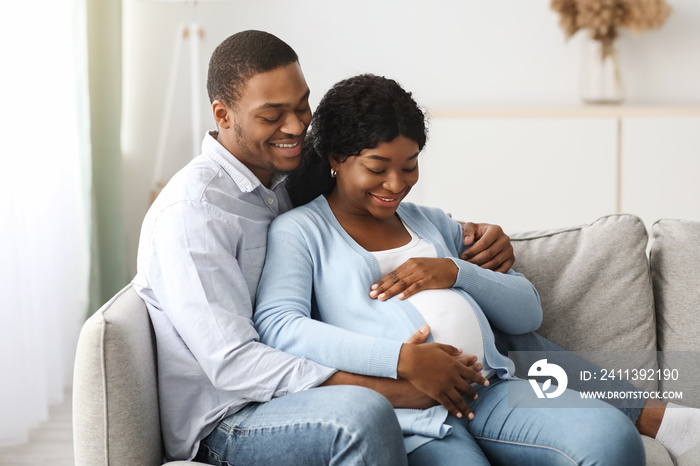 Loving pregnant couple enjoying time together at home