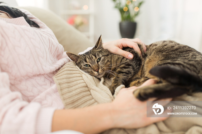 close up of owner with tabby cat in bed at home