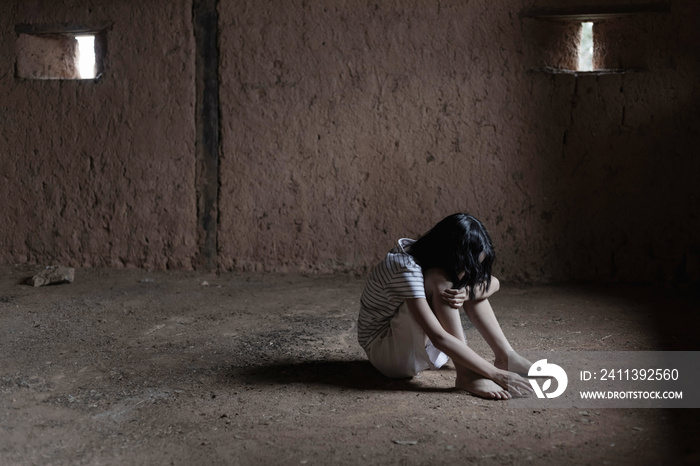 sad and unhappy poor child sitting on floor