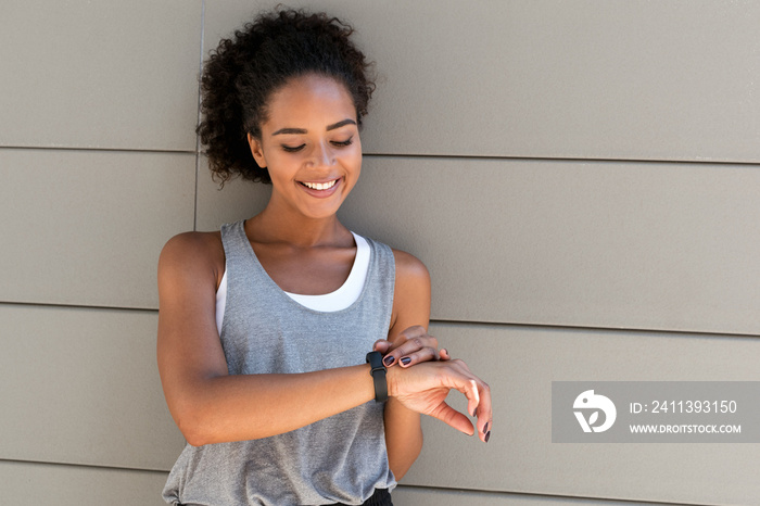 Young smiling woman checking her activity tracker