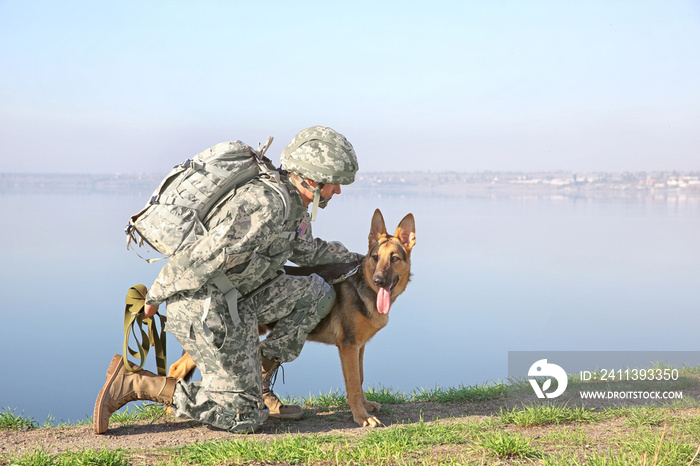 Soldier with german shepherd dog near river