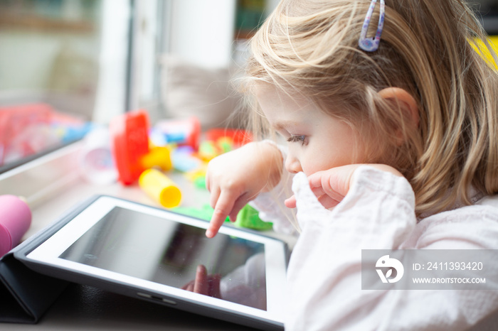 Female toddler playing on a tablet