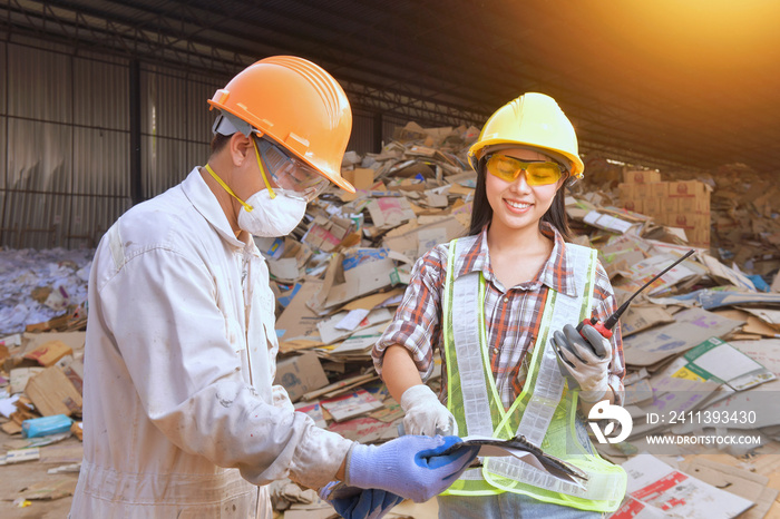 workers talking in recycling factory,a worker who recycling thing on recycle center,engineers standing in recycling center