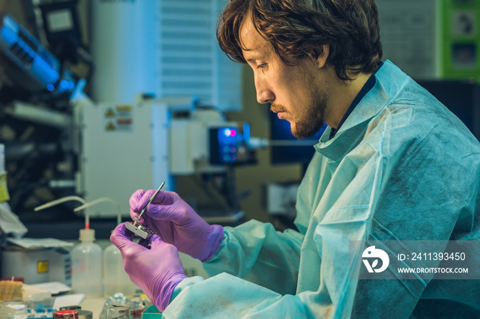 Scientist in a laboratory prepare a sample for an elecron microscopic investigation