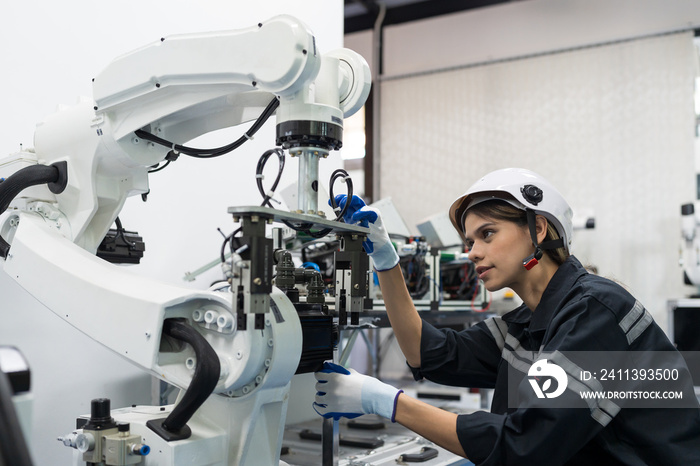 Female engineer control autonomous mobile robot or AMR in the manufacturing automation and robotics academy room. Woman engineer training or maintenance AI robot