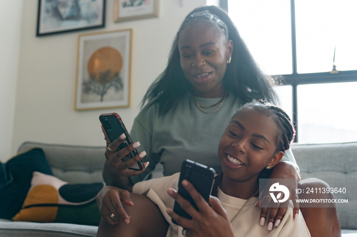 Lesbian couple using smart phones at home