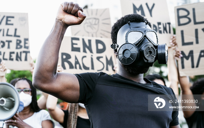 Activist wearing gas mask protesting against racism and fighting for equality - Black lives matter demonstration on street for justice and equal rights - Blm international movement concept