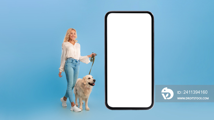 Young woman walking her dog near big smartphone