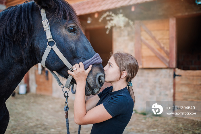 Beautiful girl enjoying with her horse outdoors at ranch.