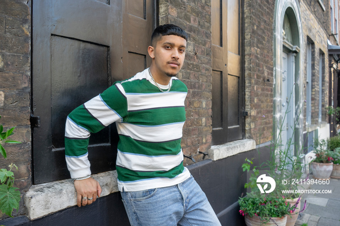 Man wearing striped sweatshirt looking at camera