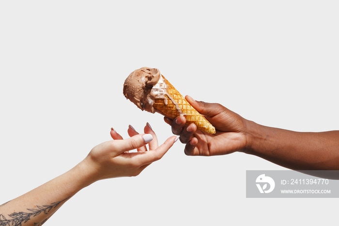 Male hand holding a waffle cone with ice cream.