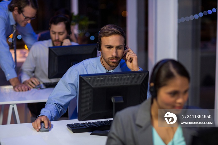 Businessman with headsets using computer in office