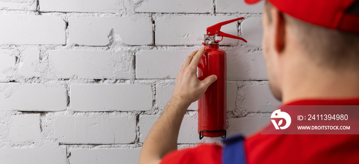 safety equipment servicing and maintenance - service worker checking fire extinguisher condition. copy space