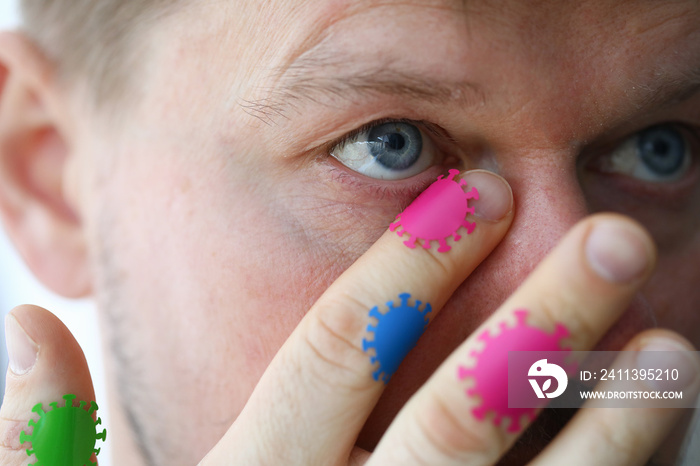 Close-up of male hand scratching eye with microbes on it. Dont touch face. Macro shot of germs on skin. Invisible organism. Hygiene and hand-washing concept