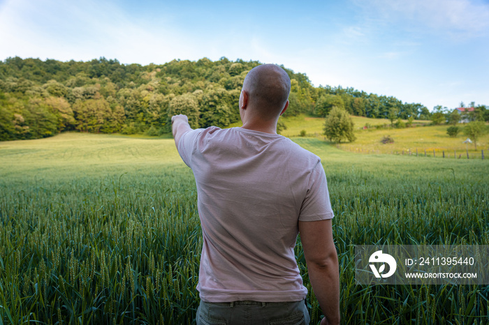 Young farmer pointing at something in the distance