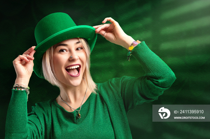 St. Patrick’s Day leprechaun model woman on green magic background with shamrock leaves.