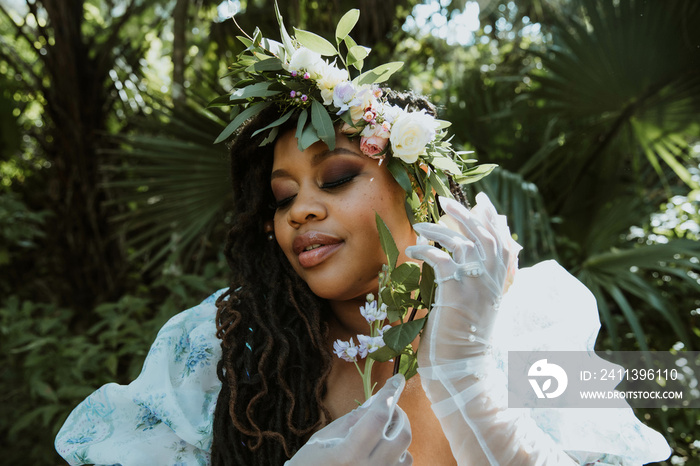 closeup of a plus size black woman holding flowers next to face